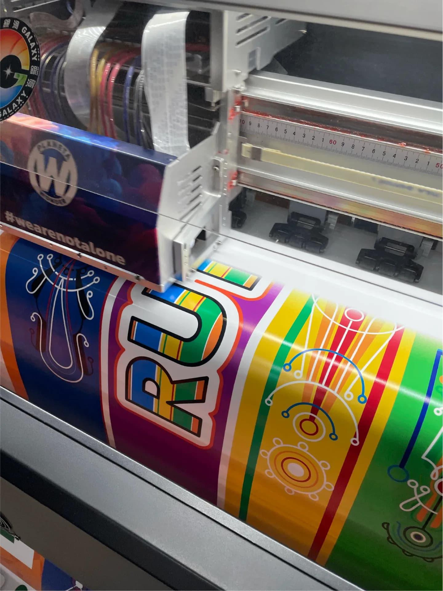 Impresora de gran formato del taller imprimiendo un vinilo a color